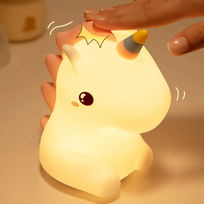main qui appuie sur veilleuse pour bebe licorne 