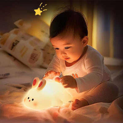 veilleuse bébé lapin dans les mains d'un bébé