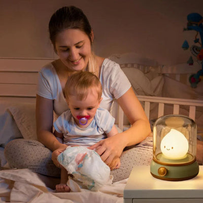veilleuse_goutte_d_eau_et_bebe_assis_sur_jambe_de_sa_maman